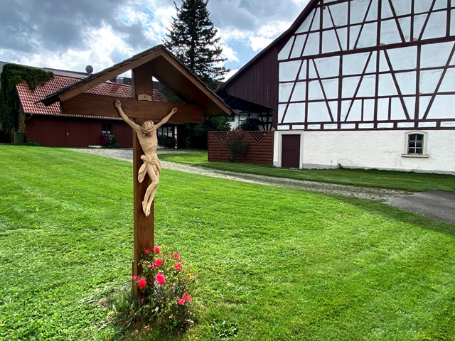 Wegkreuz im Dorf Osterhofen vor Fachwerkgebude